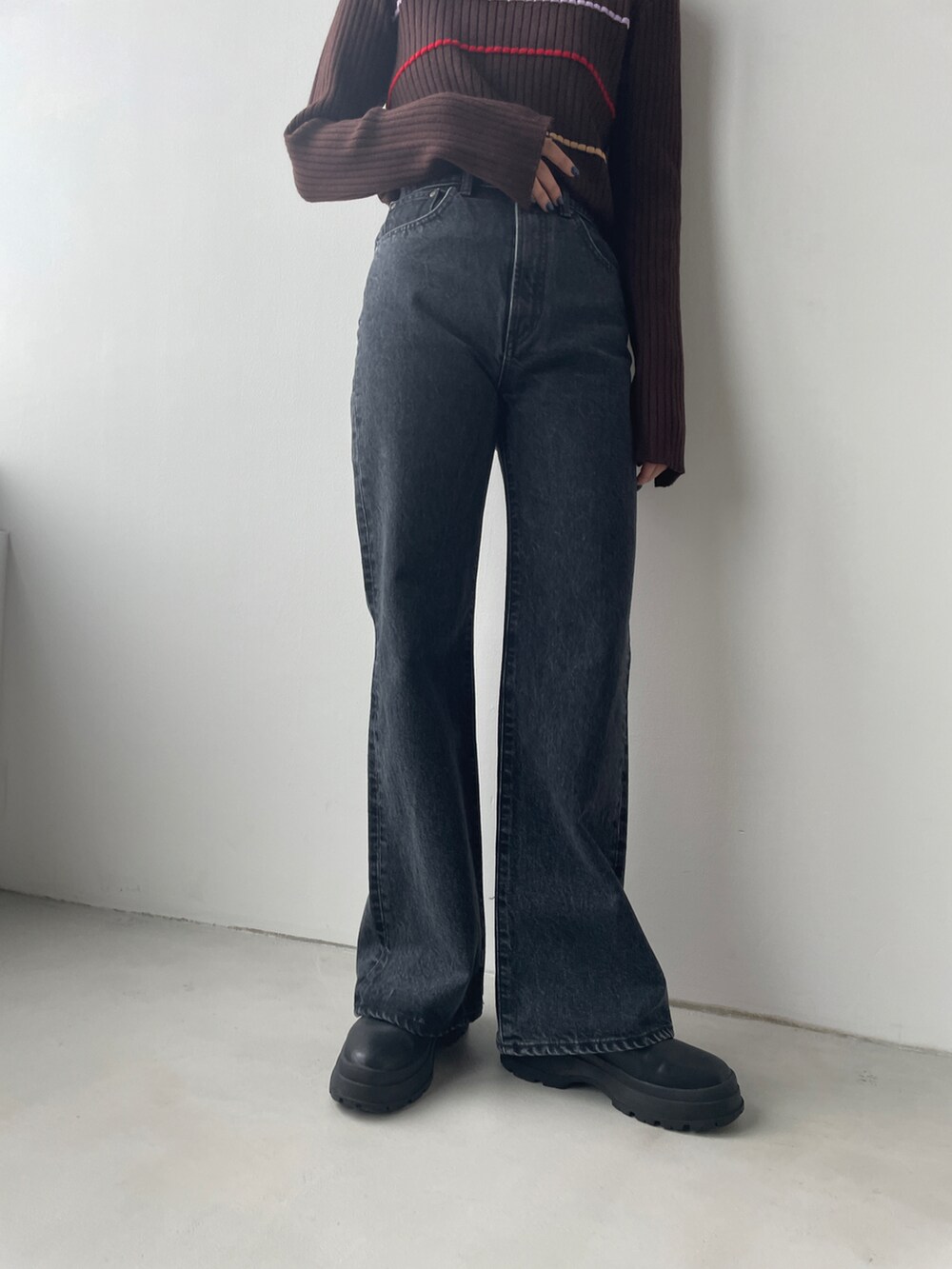 ブラウン系のニット/セーター、ブラック系のデニムパンツを着用したレディースの秋コーディネートの2枚目の写真