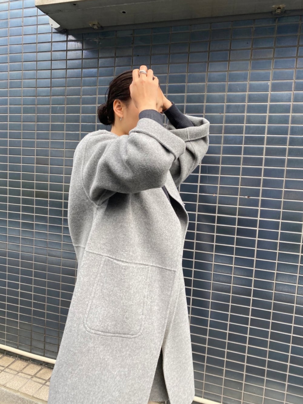 ホワイト系のデニムパンツ、グレー系のノーカラーコートを着用したレディースの秋コーディネートの3枚目の写真