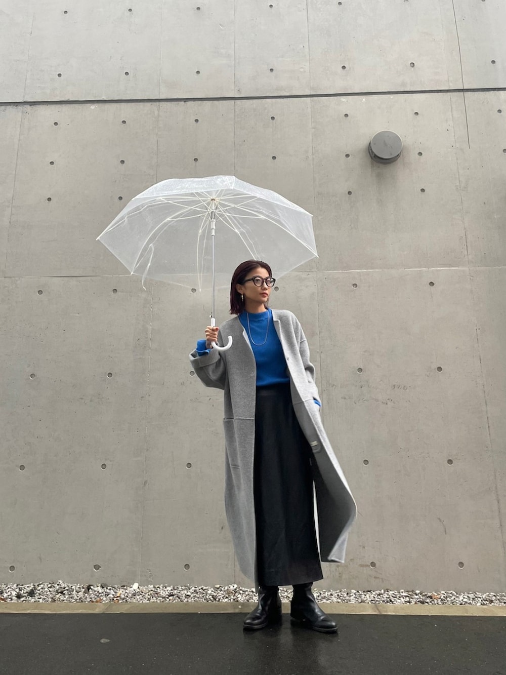 グレー系のノーカラーコートを着用したレディースの秋コーディネートの2枚目の写真