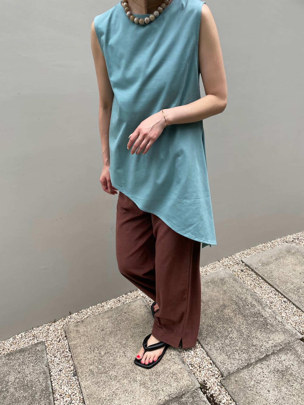 ブルー系のタンクトップ、ブラウン系のその他パンツ、ブラック系のサンダルを着用したレディースの夏コーディネートの2枚目の写真