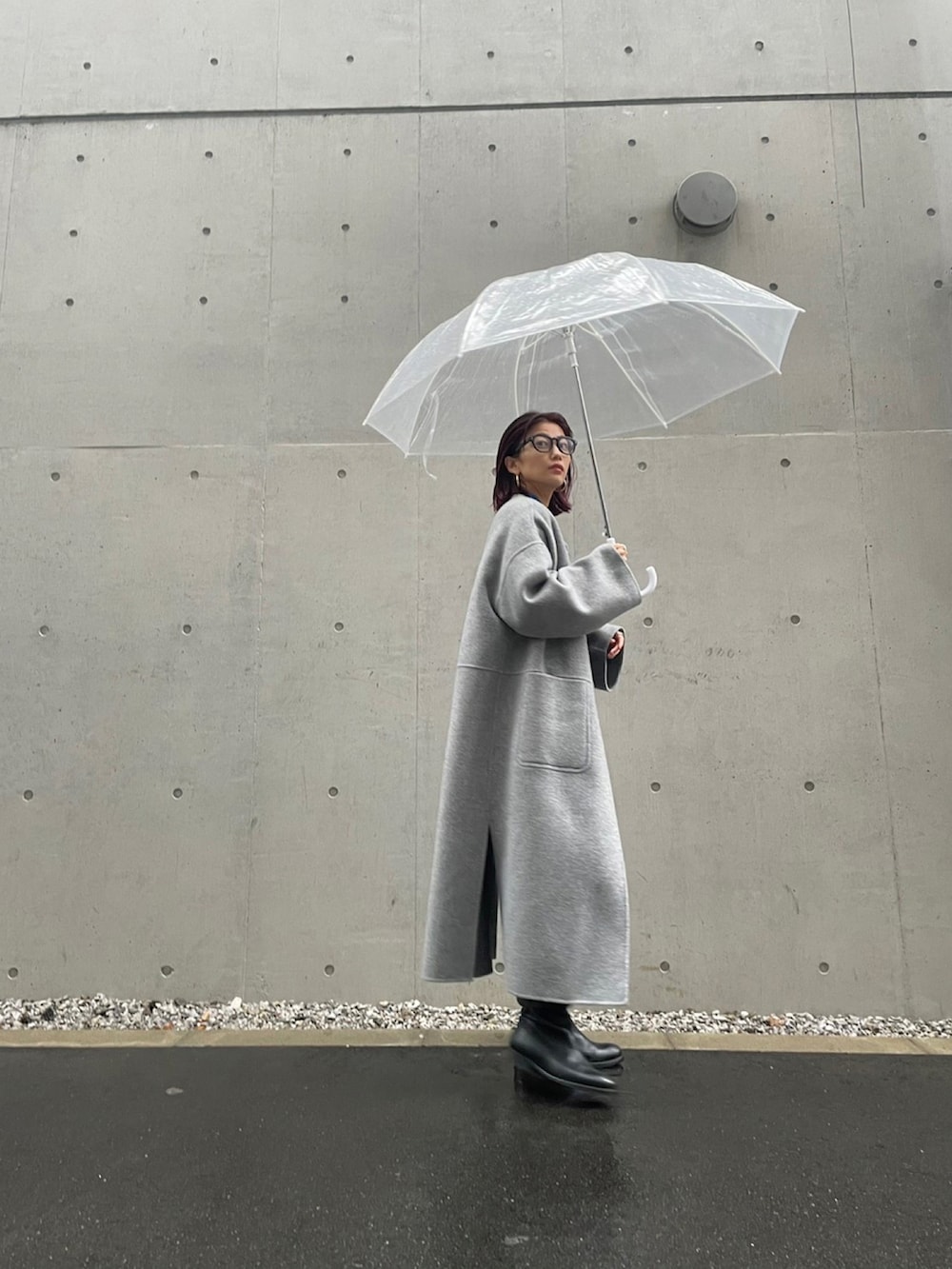 グレー系のノーカラーコートを着用したレディースの秋コーディネートの3枚目の写真