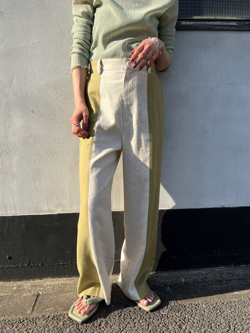 ベージュ系のその他パンツ、グリーン系のTシャツ/カットソー、グリーン系のサンダルを着用したレディースの夏コーディネートの2枚目の写真