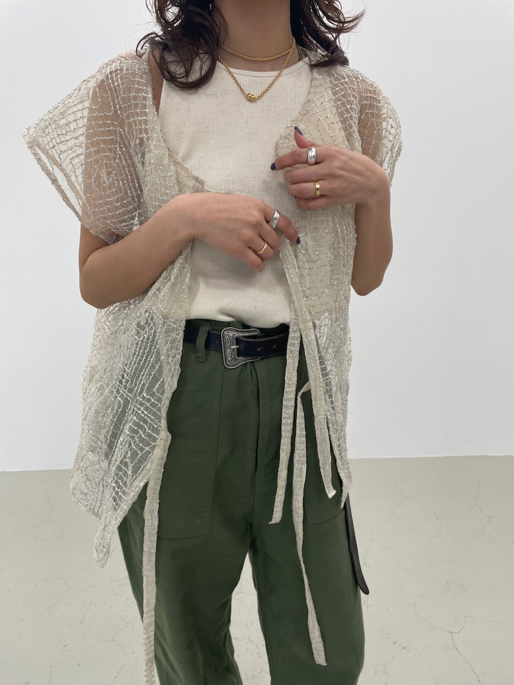 シルバー系のカーディガン/ボレロ、グリーン系のカーゴパンツ、ブラック系のサンダルを着用したレディースの春コーディネートの3枚目の写真