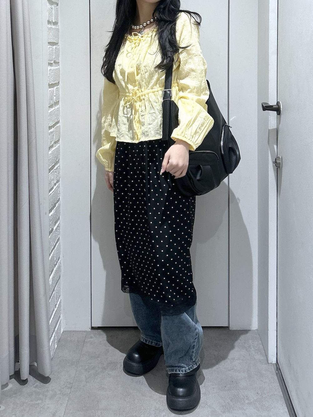 イエロー系のシャツ/ブラウス、ブラック系のトートバッグ、ブラック系のスカートを着用したレディースの春コーディネートの3枚目の写真