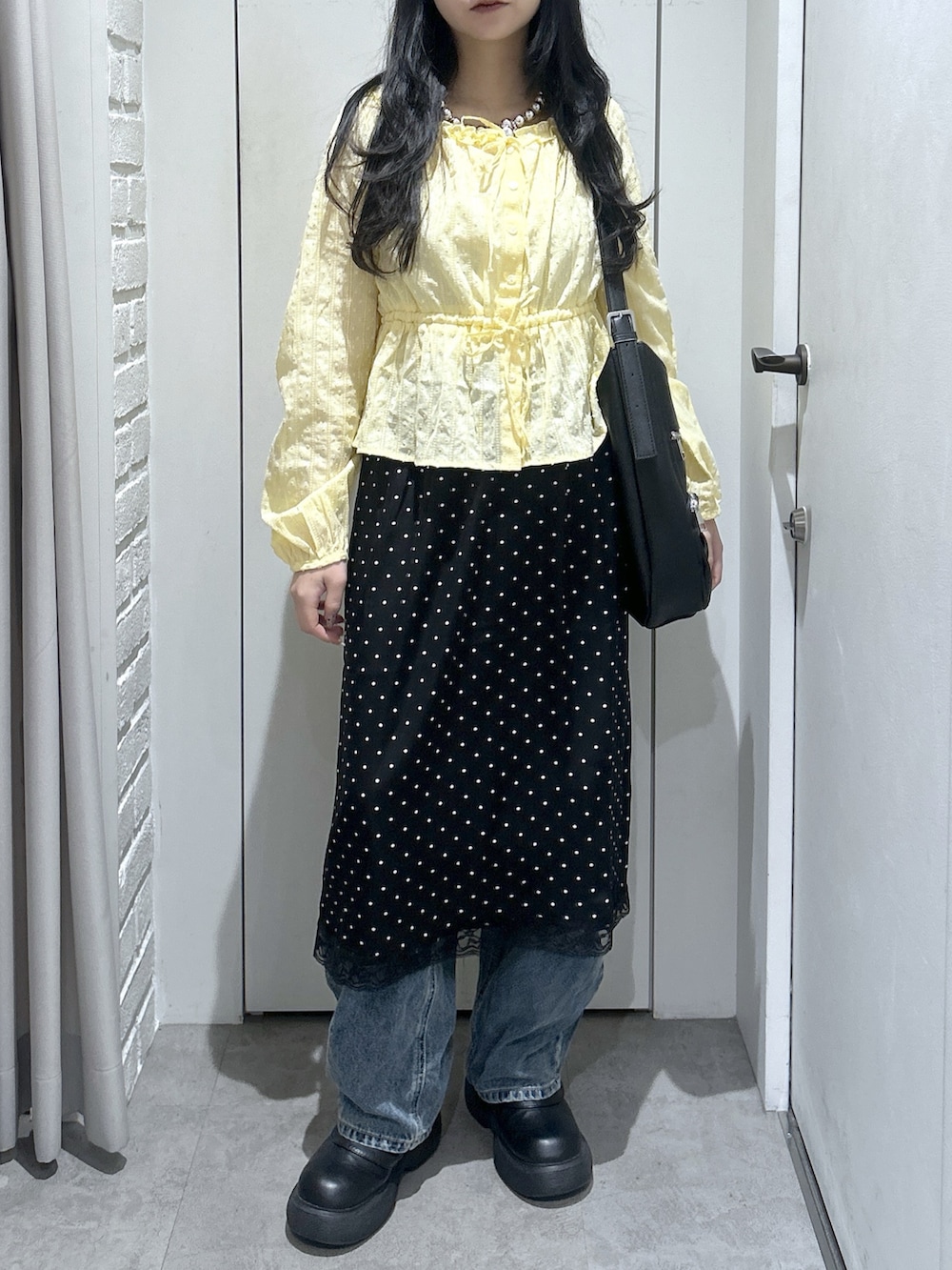 イエロー系のシャツ/ブラウス、ブラック系のトートバッグ、ブラック系のスカートを着用したレディースの春コーディネートの4枚目の写真