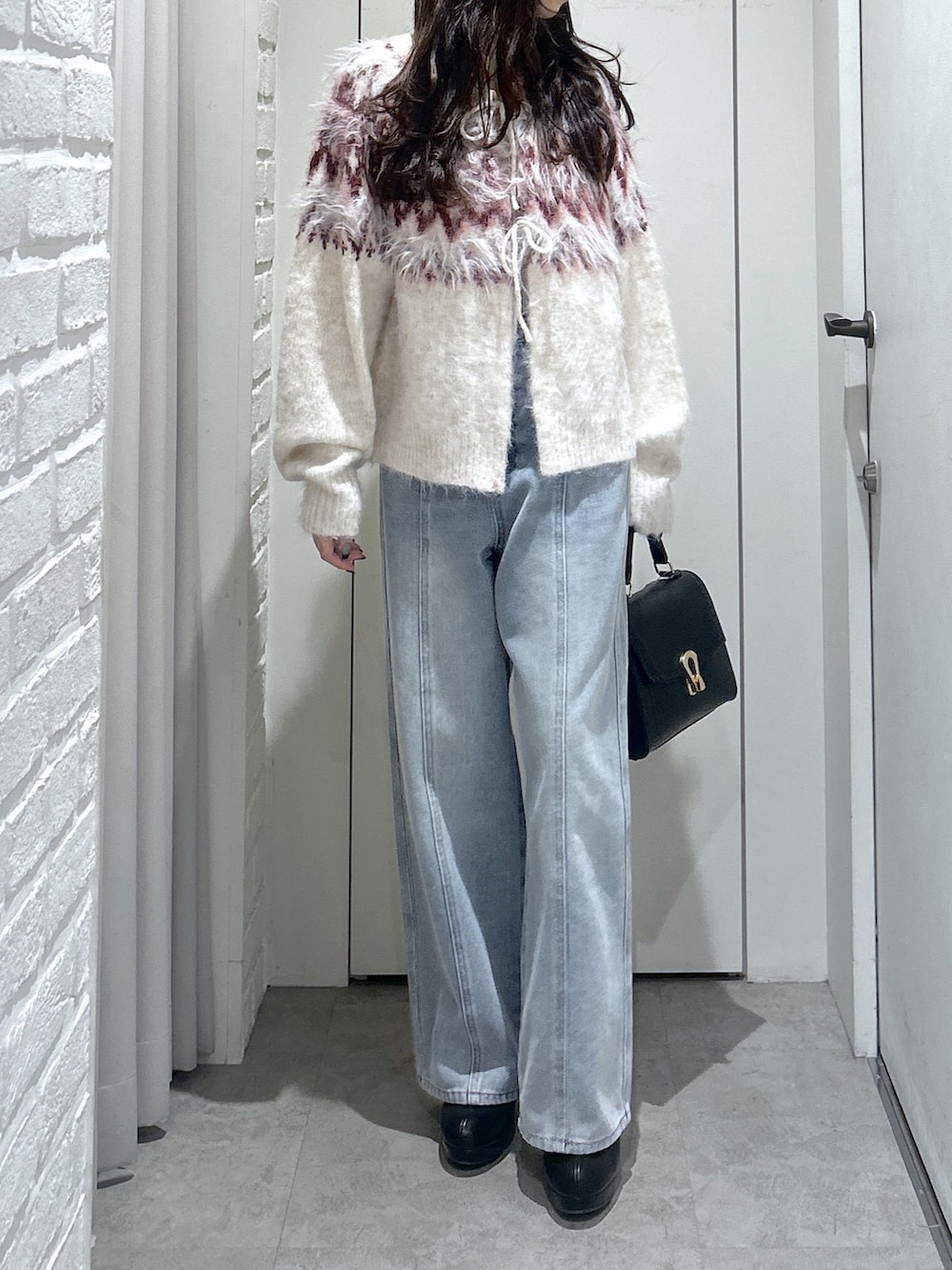 ホワイト系のニット/セーター、ブルー系のデニムパンツ、ブラック系のトートバッグを着用したレディースの秋コーディネートの4枚目の写真