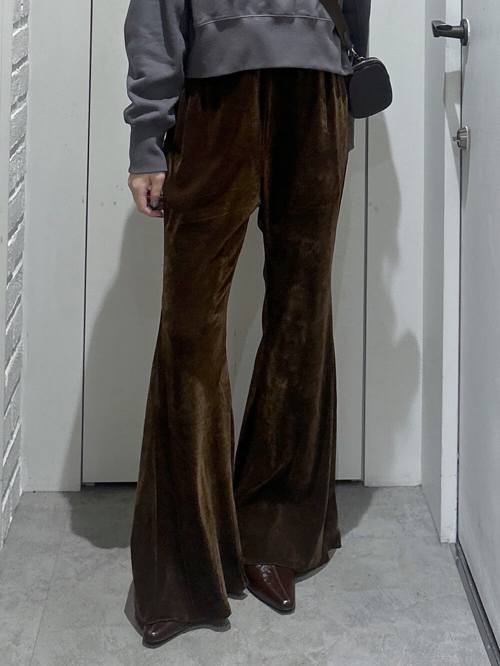 ブラック系のスウェット、ブラウン系のショルダーバッグ、ブラウン系のその他パンツを着用したレディースの秋コーディネートの5枚目の写真