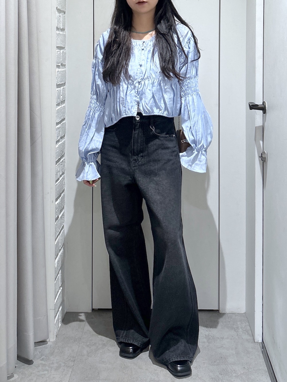 ブラック系のデニムパンツ、ブルー系のシャツ/ブラウス、ブラック系のローファーを着用したレディースの春コーディネートの2枚目の写真