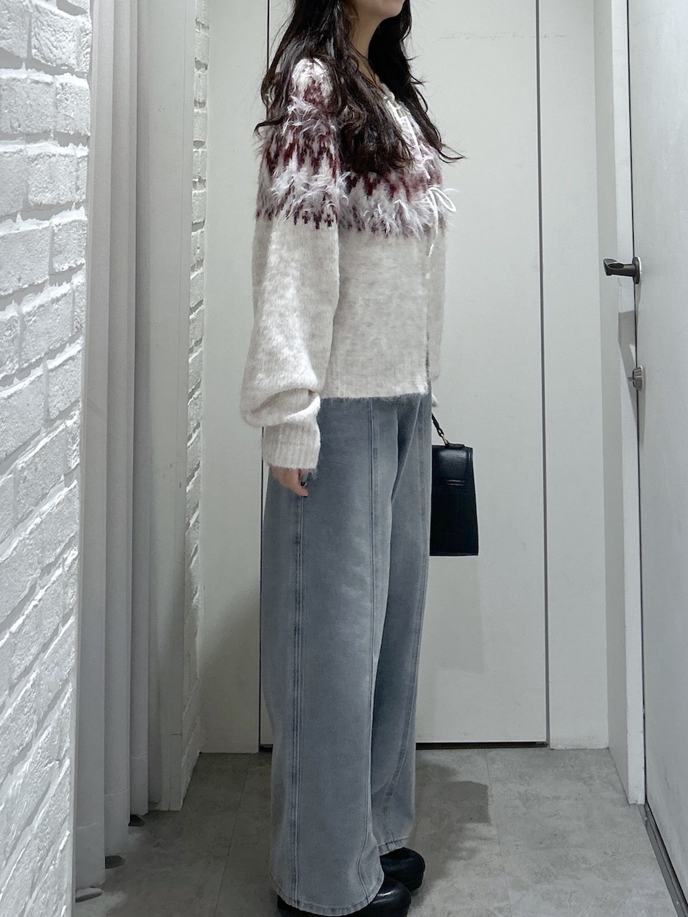 ホワイト系のニット/セーター、ブルー系のデニムパンツ、ブラック系のトートバッグを着用したレディースの秋コーディネートの6枚目の写真