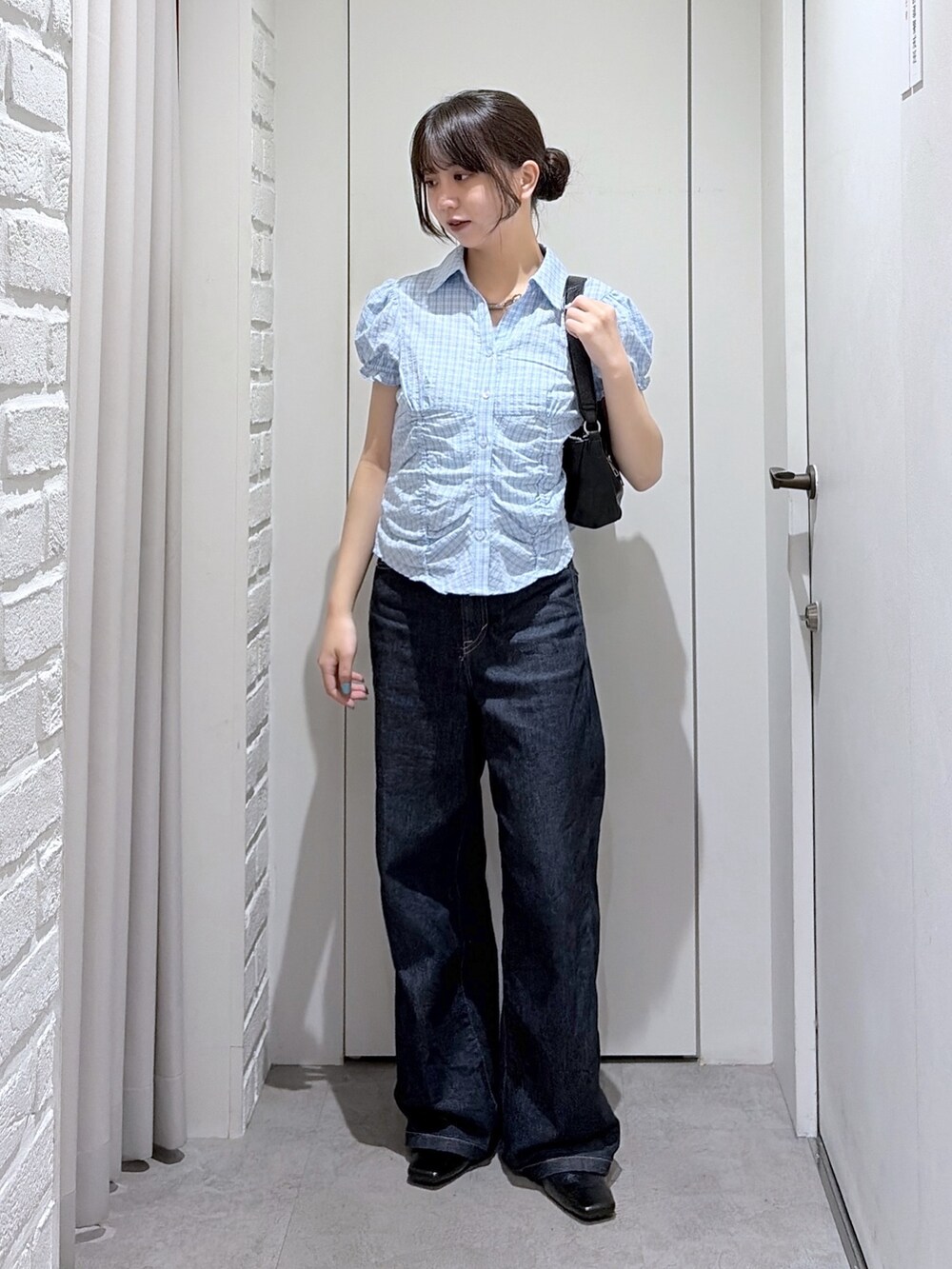 ブルー系のデニムパンツ、ブルー系のシャツ/ブラウス、ブラック系のショルダーバッグを着用したレディースの夏コーディネートの2枚目の写真