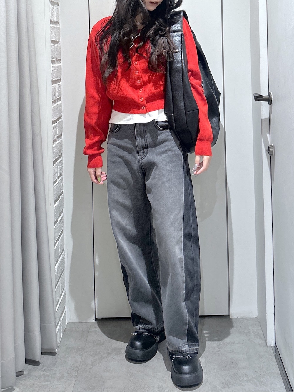 ブラック系のトートバッグ、レッド系のニット/セーターを着用したレディースの春コーディネートの4枚目の写真