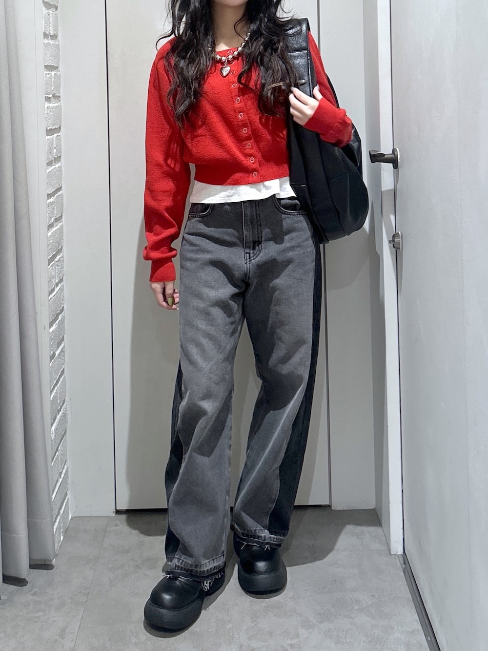 ブラック系のトートバッグ、レッド系のニット/セーターを着用したレディースの春コーディネートの3枚目の写真