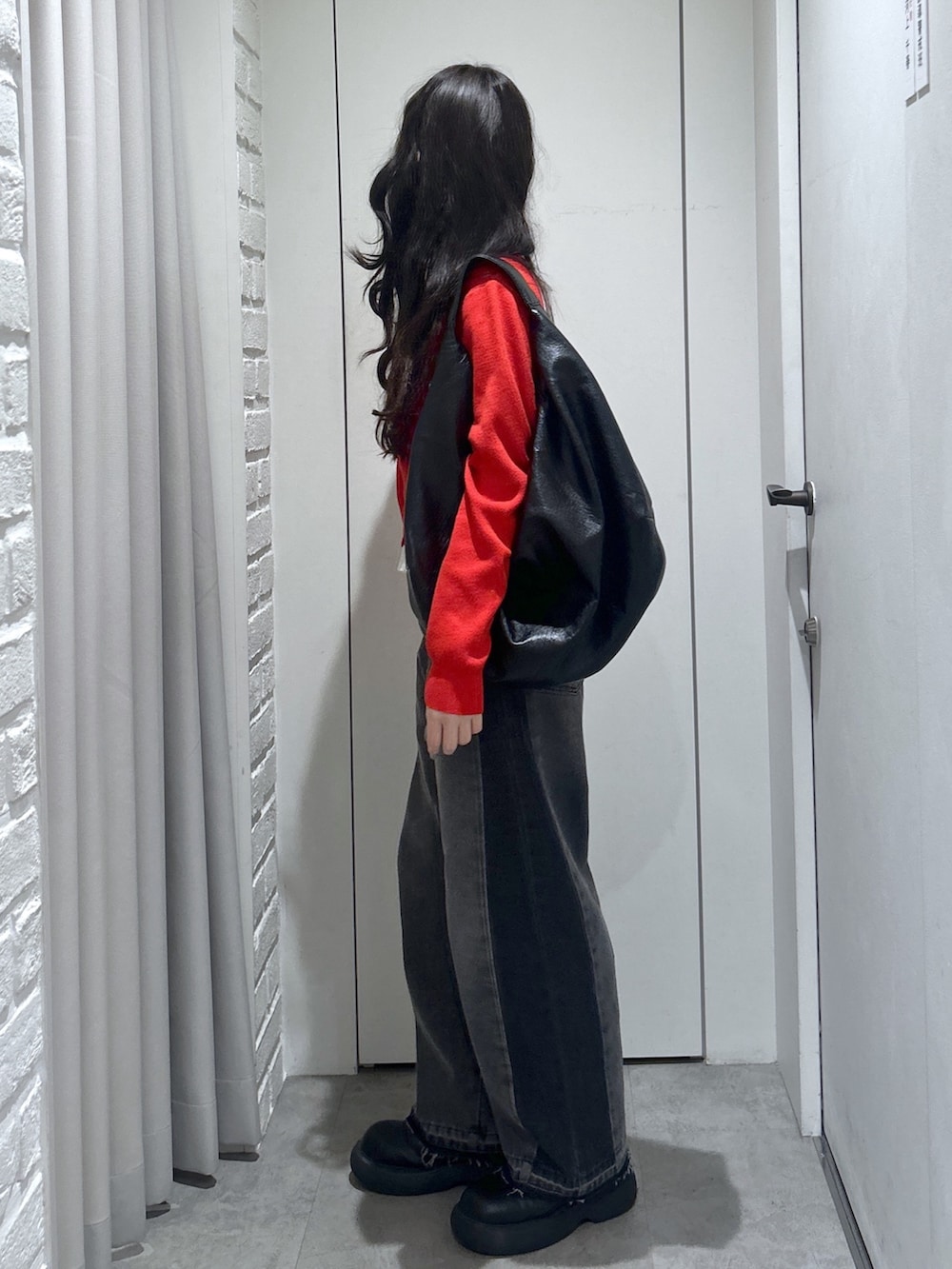 ブラック系のトートバッグ、レッド系のニット/セーターを着用したレディースの春コーディネートの5枚目の写真