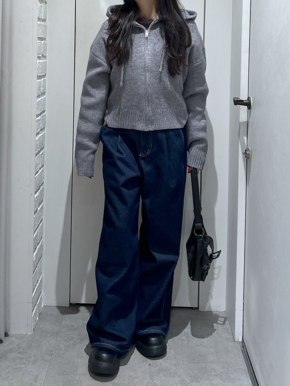 グレー系のニット/セーター、ブルー系のその他パンツ、ブラック系のショルダーバッグを着用したレディースの冬コーディネートの3枚目の写真