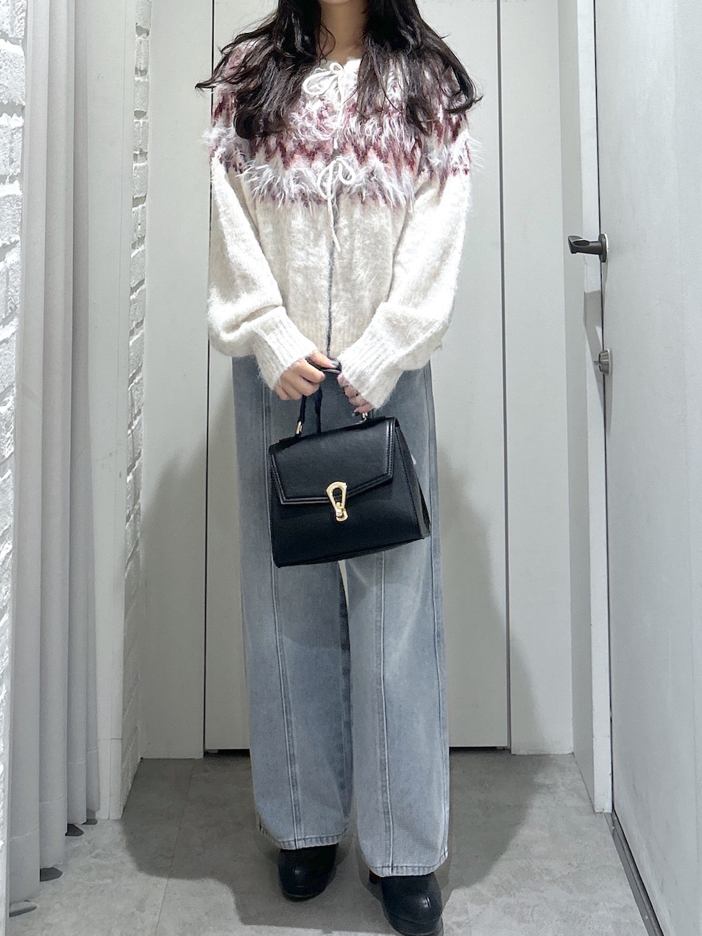 ホワイト系のニット/セーター、ブルー系のデニムパンツ、ブラック系のトートバッグを着用したレディースの秋コーディネートの5枚目の写真