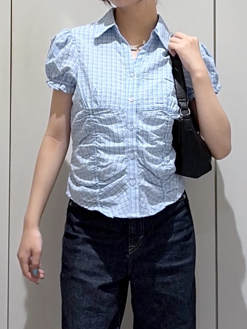 ブルー系のデニムパンツ、ブルー系のシャツ/ブラウス、ブラック系のショルダーバッグを着用したレディースの夏コーディネートの3枚目の写真