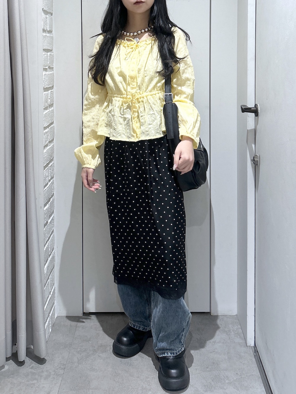イエロー系のシャツ/ブラウス、ブラック系のトートバッグ、ブラック系のスカートを着用したレディースの春コーディネートの2枚目の写真