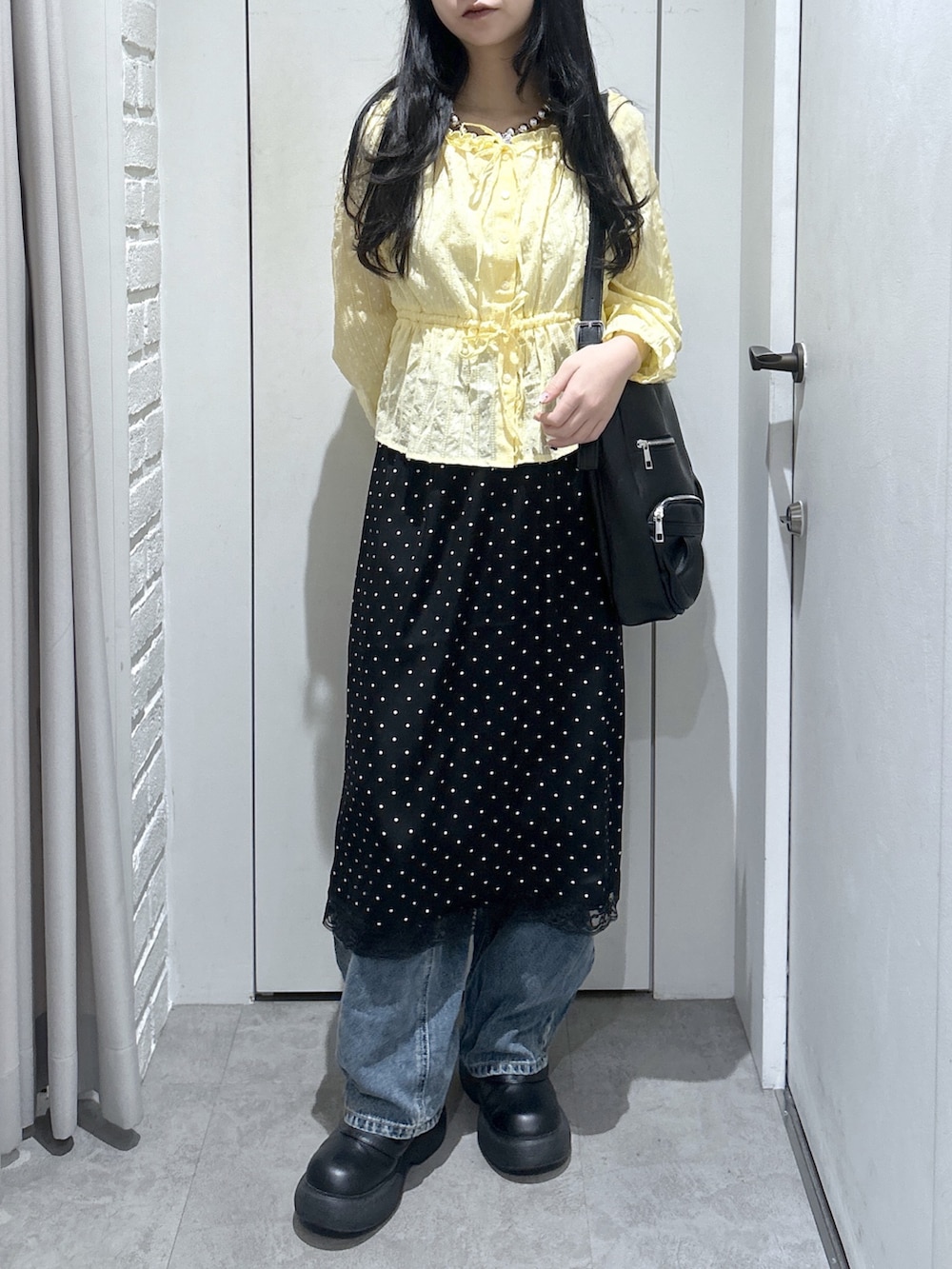 イエロー系のシャツ/ブラウス、ブラック系のトートバッグ、ブラック系のスカートを着用したレディースの春コーディネートの5枚目の写真