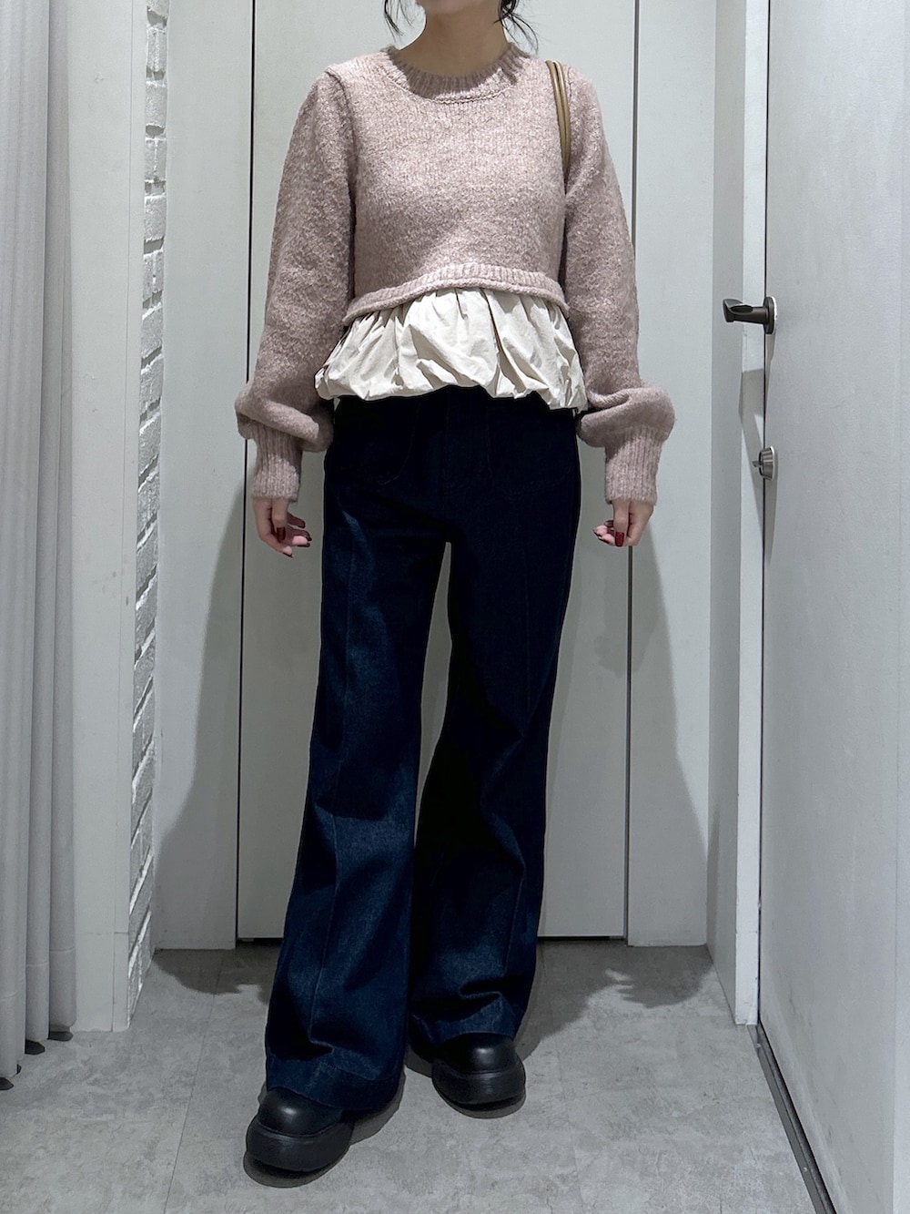 ブルー系のデニムパンツ、ベージュ系のニット/セーター、ベージュ系のショルダーバッグを着用したレディースの冬コーディネートの4枚目の写真