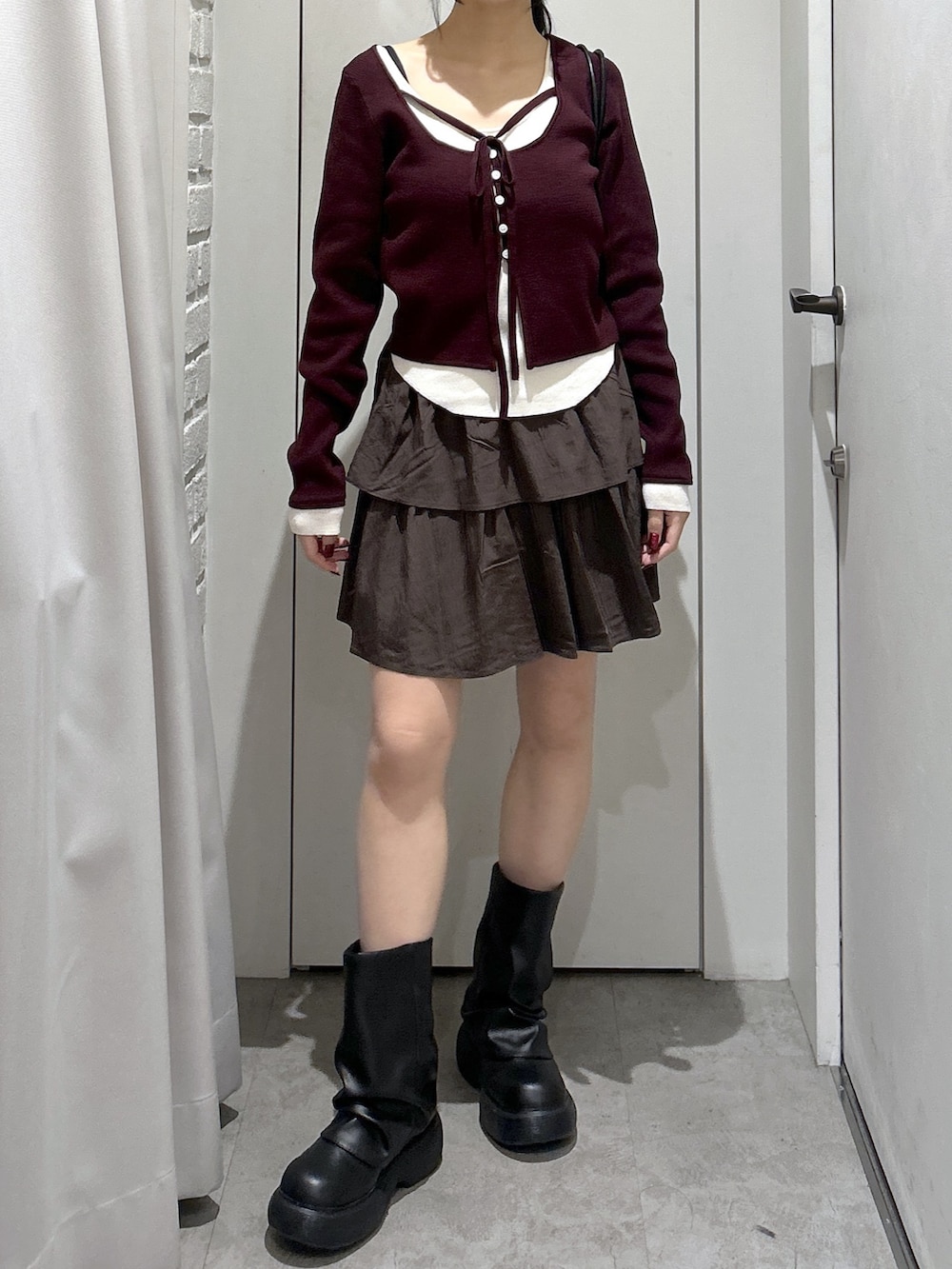 ブラウン系のスカート、ブラック系のショルダーバッグを着用したレディースの冬コーディネートの4枚目の写真