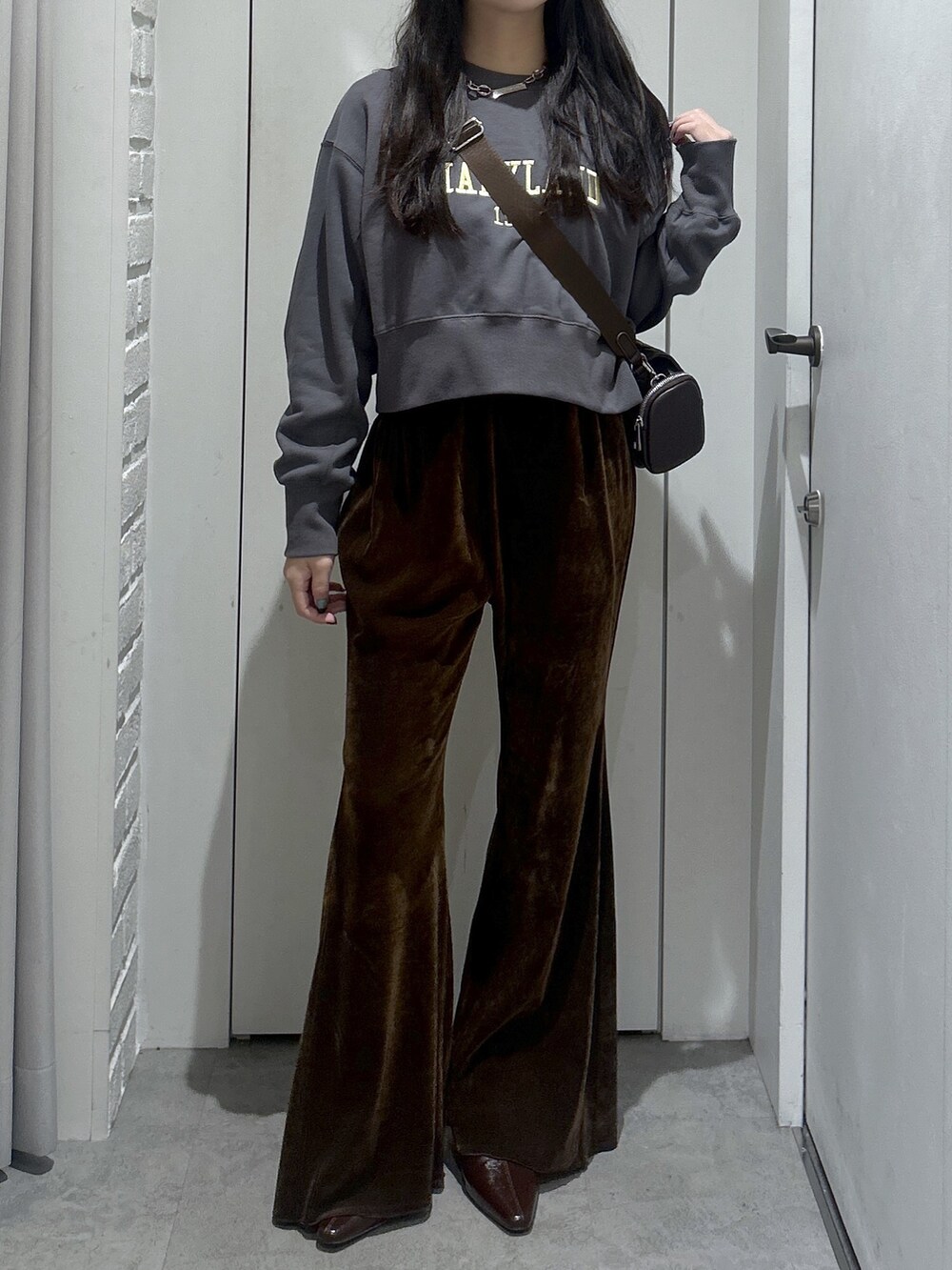 ブラック系のスウェット、ブラウン系のショルダーバッグ、ブラウン系のその他パンツを着用したレディースの秋コーディネートの3枚目の写真