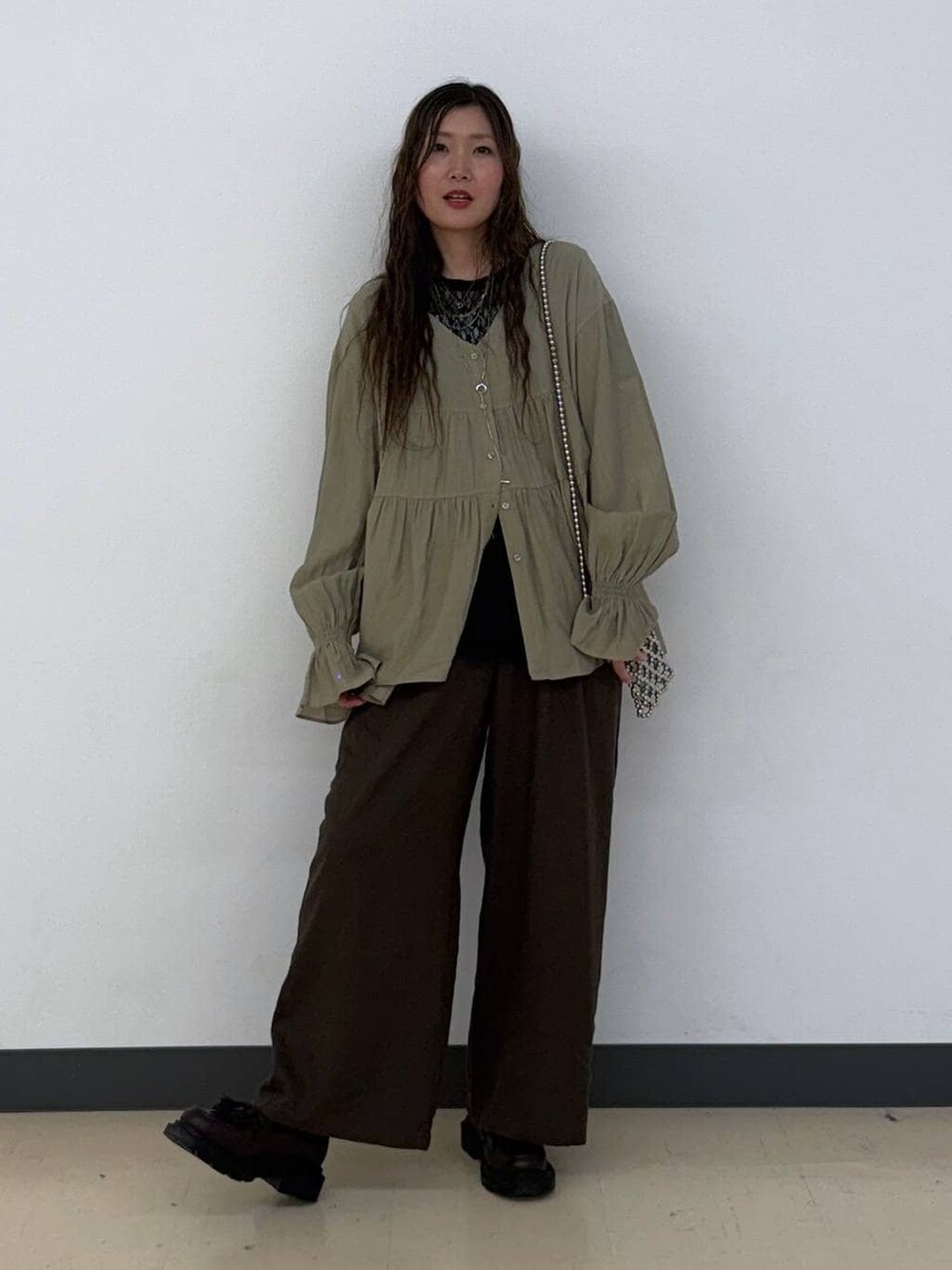 ブラウン系のその他パンツ、ブラック系のその他トップスを着用したレディースの春コーディネートの2枚目の写真