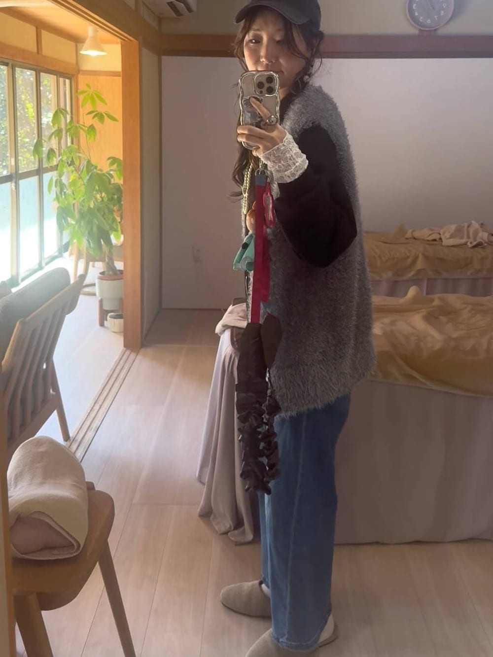 グレー系のベスト、ブルー系のデニムパンツ、ブラック系のTシャツ/カットソーを着用したレディースの春コーディネートの4枚目の写真