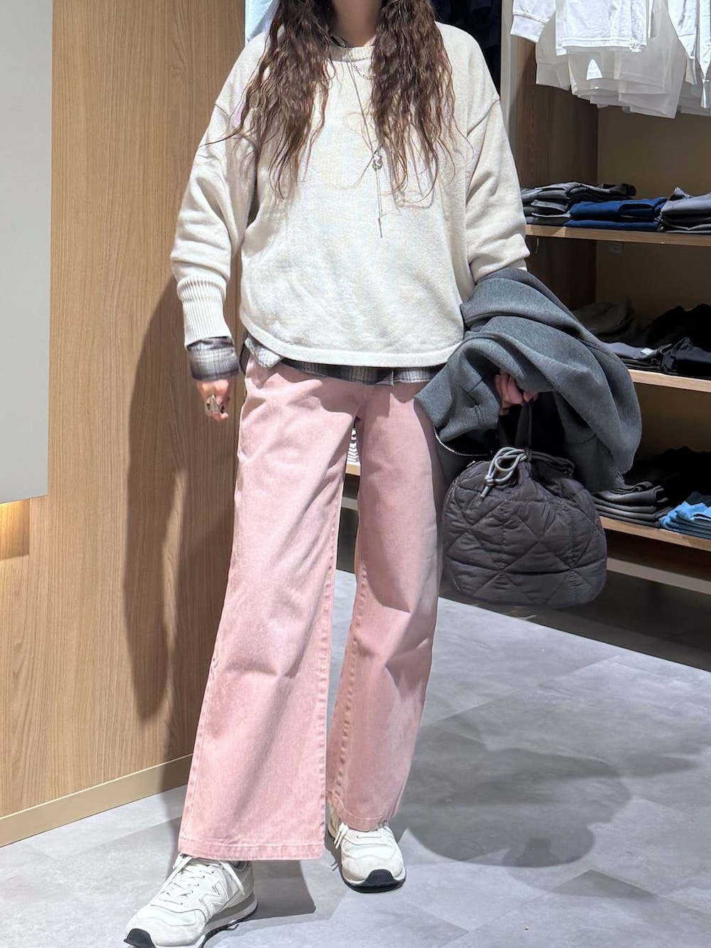 ベージュ系のニット/セーター、グレー系のハンドバッグ、ピンク系のデニムパンツを着用したレディースの春コーディネートの5枚目の写真