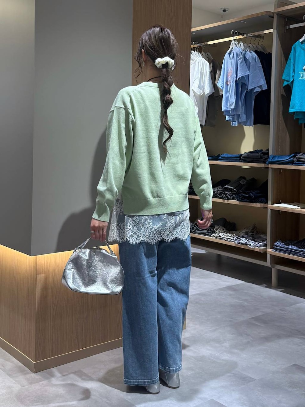 シルバー系のショルダーバッグ、シルバー系のパンプス、グリーン系のニット/セーターを着用したレディースの春コーディネートの4枚目の写真