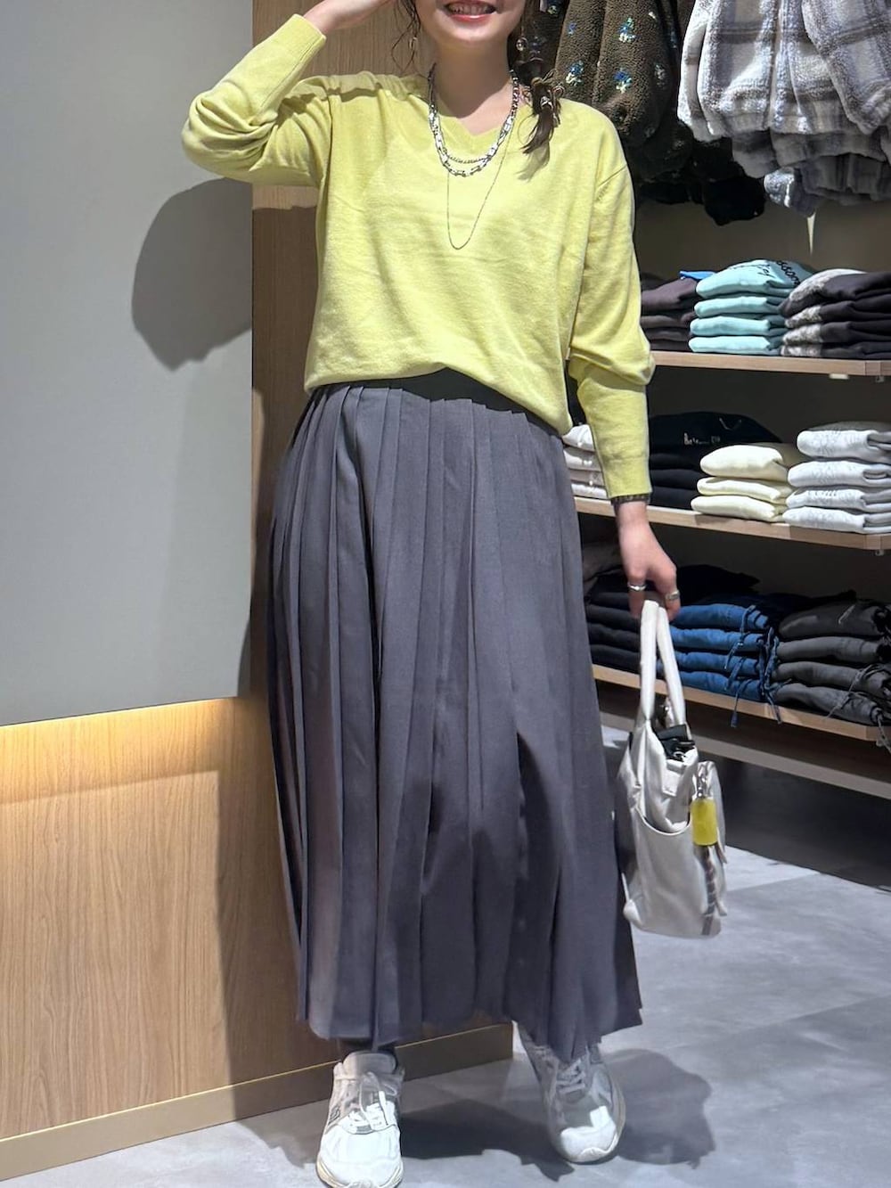 ホワイト系のトートバッグ、グレー系のスカート、イエロー系のニット/セーターを着用したレディースの秋コーディネートの5枚目の写真
