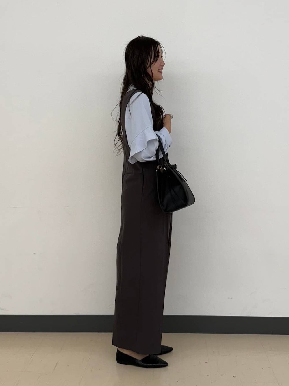 ブラック系のショルダーバッグ、ブラック系のパンプス、グレー系のセットアップを着用したレディースの冬コーディネートの4枚目の写真