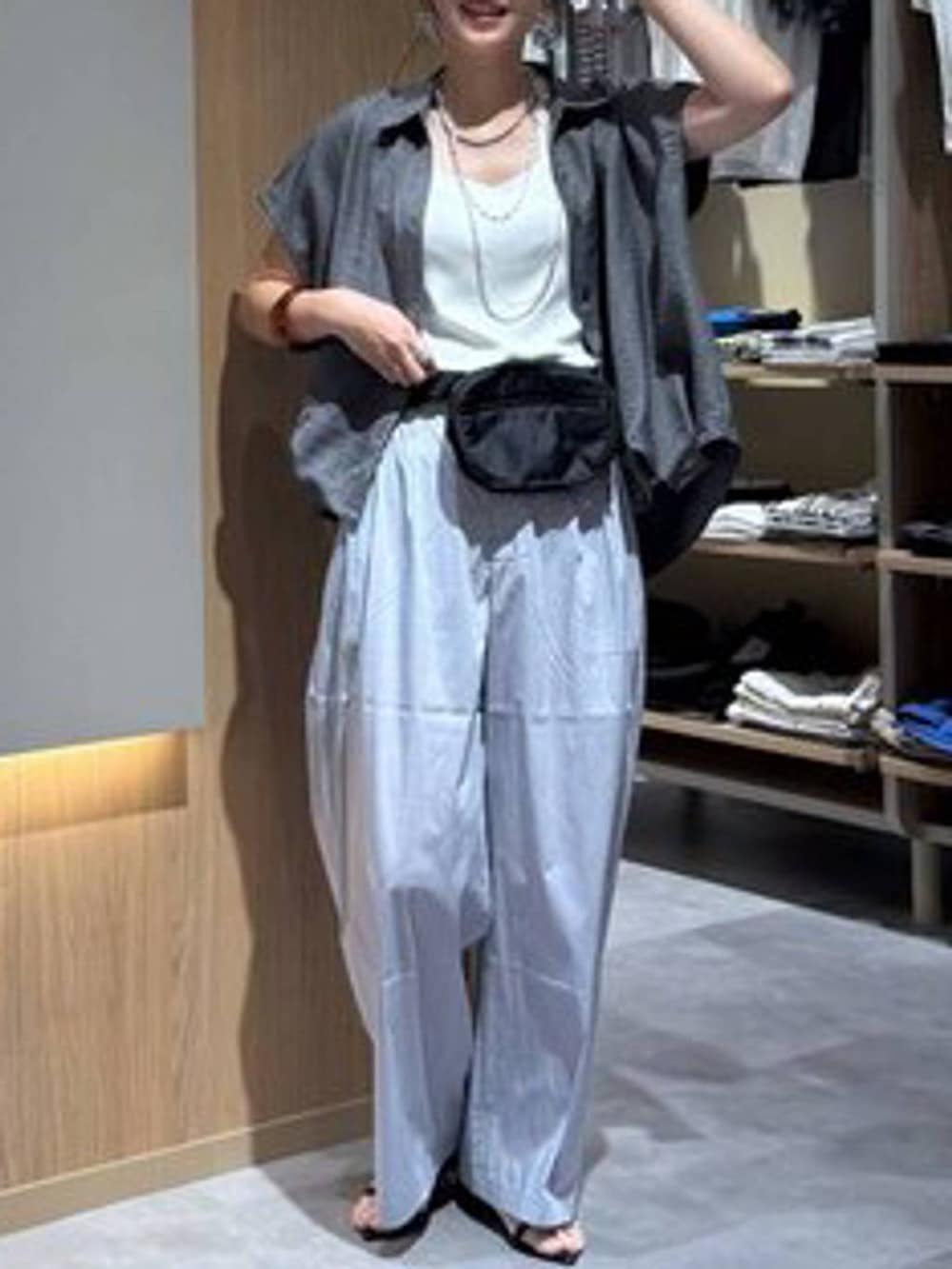 グレー系のその他パンツ、ホワイト系のタンクトップ、ブラック系のボディバッグ/ウエストポーチを着用したレディースの夏コーディネートの5枚目の写真