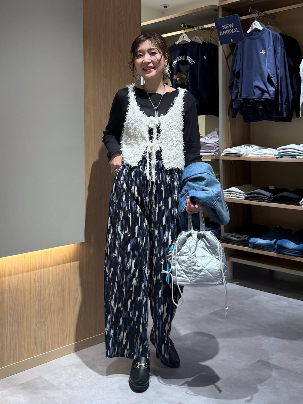 ブラック系のローファー、シルバー系のハンドバッグ、ブルー系のデニムジャケットを着用したレディースの春コーディネートの6枚目の写真