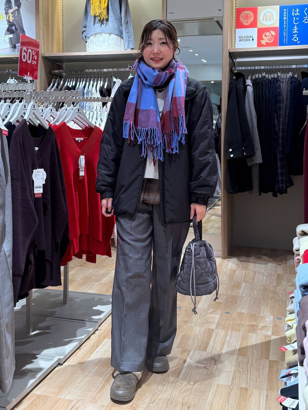 ブラック系のブルゾン、グレー系のハンドバッグ、ホワイト系のニット/セーターを着用したレディースの冬コーディネートの8枚目の写真