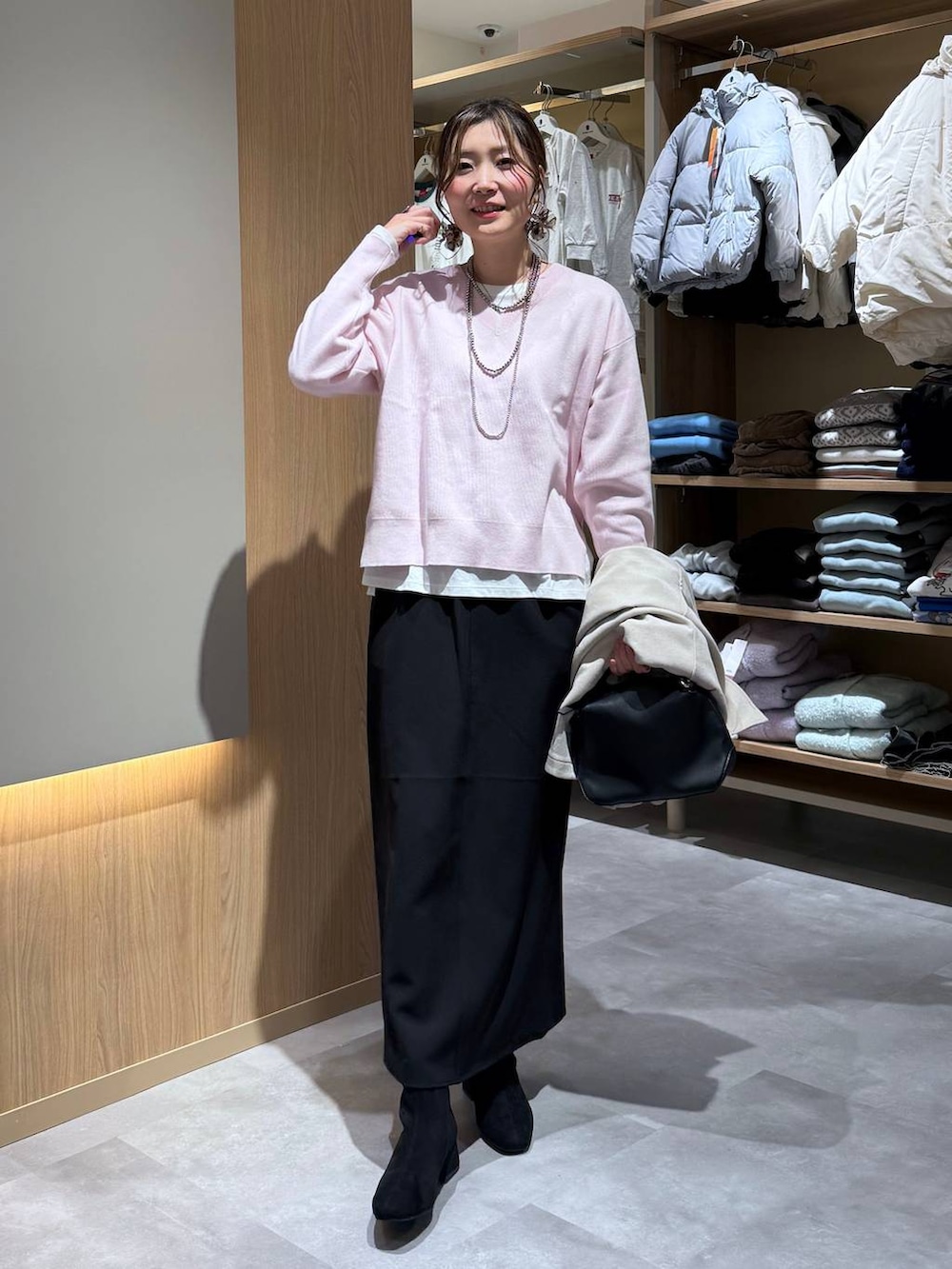 ブラック系のショルダーバッグ、ホワイト系のTシャツ/カットソー、ブラック系のブーツを着用したレディースの冬コーディネートの6枚目の写真