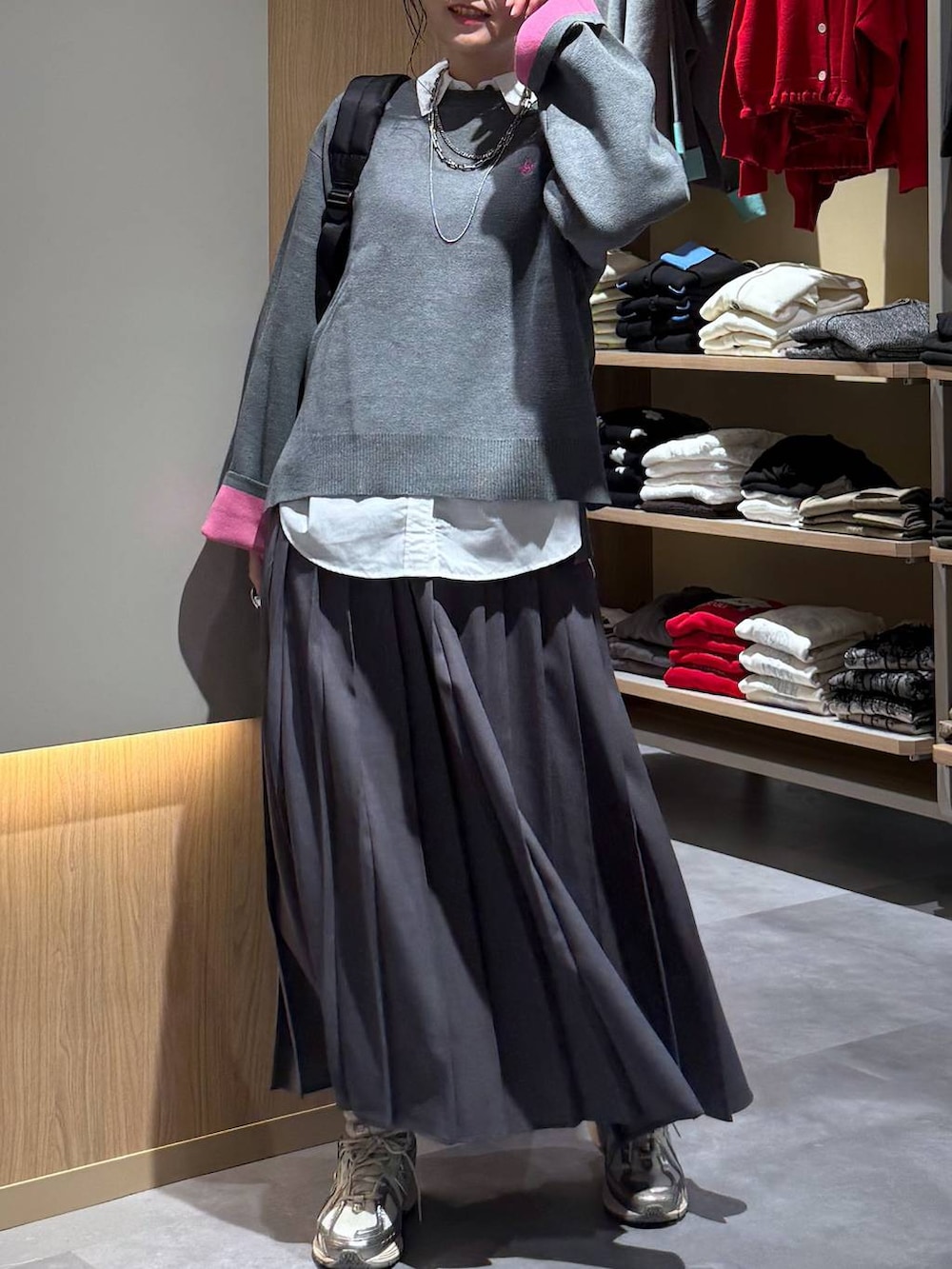 ホワイト系のシャツ/ブラウス、ブラック系のバックパック/リュック、グレー系のニット/セーターを着用したレディースの秋コーディネートの6枚目の写真