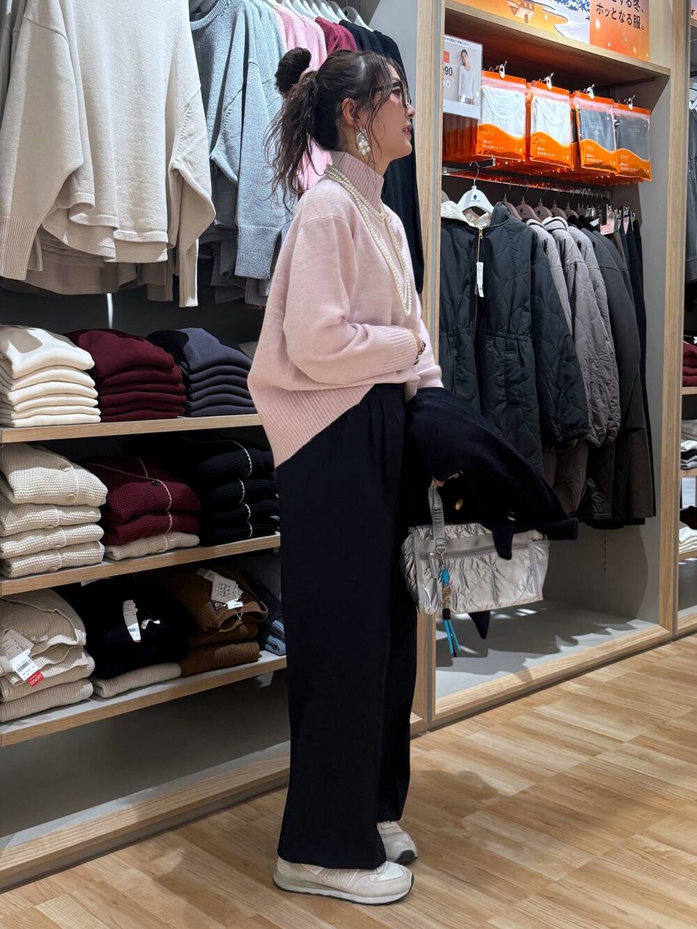 ブルー系のチェスターコート、シルバー系のボストンバッグ、ピンク系のニット/セーターを着用したレディースの冬コーディネートの7枚目の写真