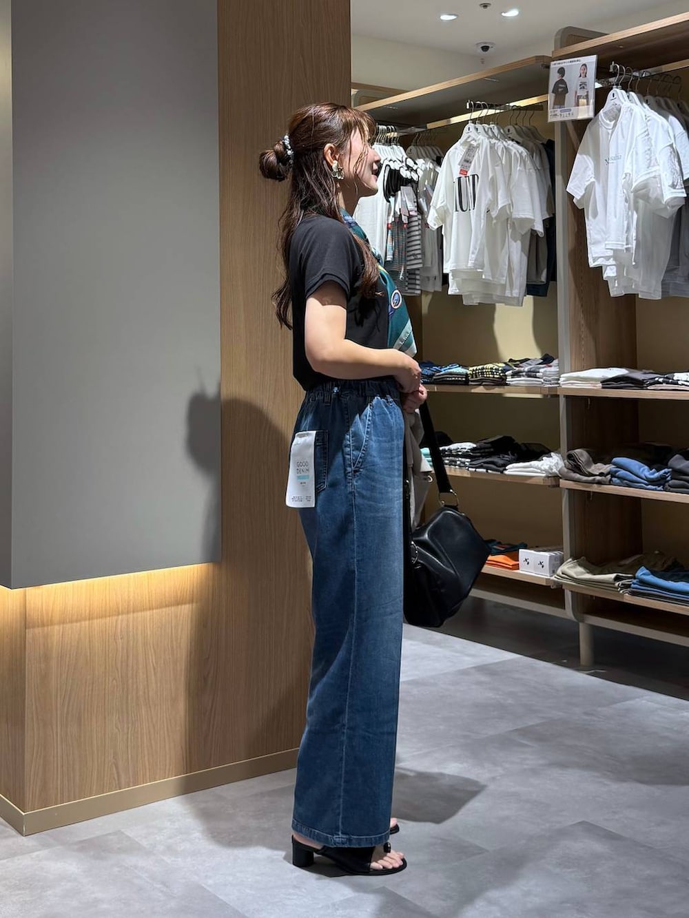 ブルー系のデニムパンツ、ベージュ系のテーラードジャケット、ブラック系のサンダルを着用したレディースの夏コーディネートの7枚目の写真