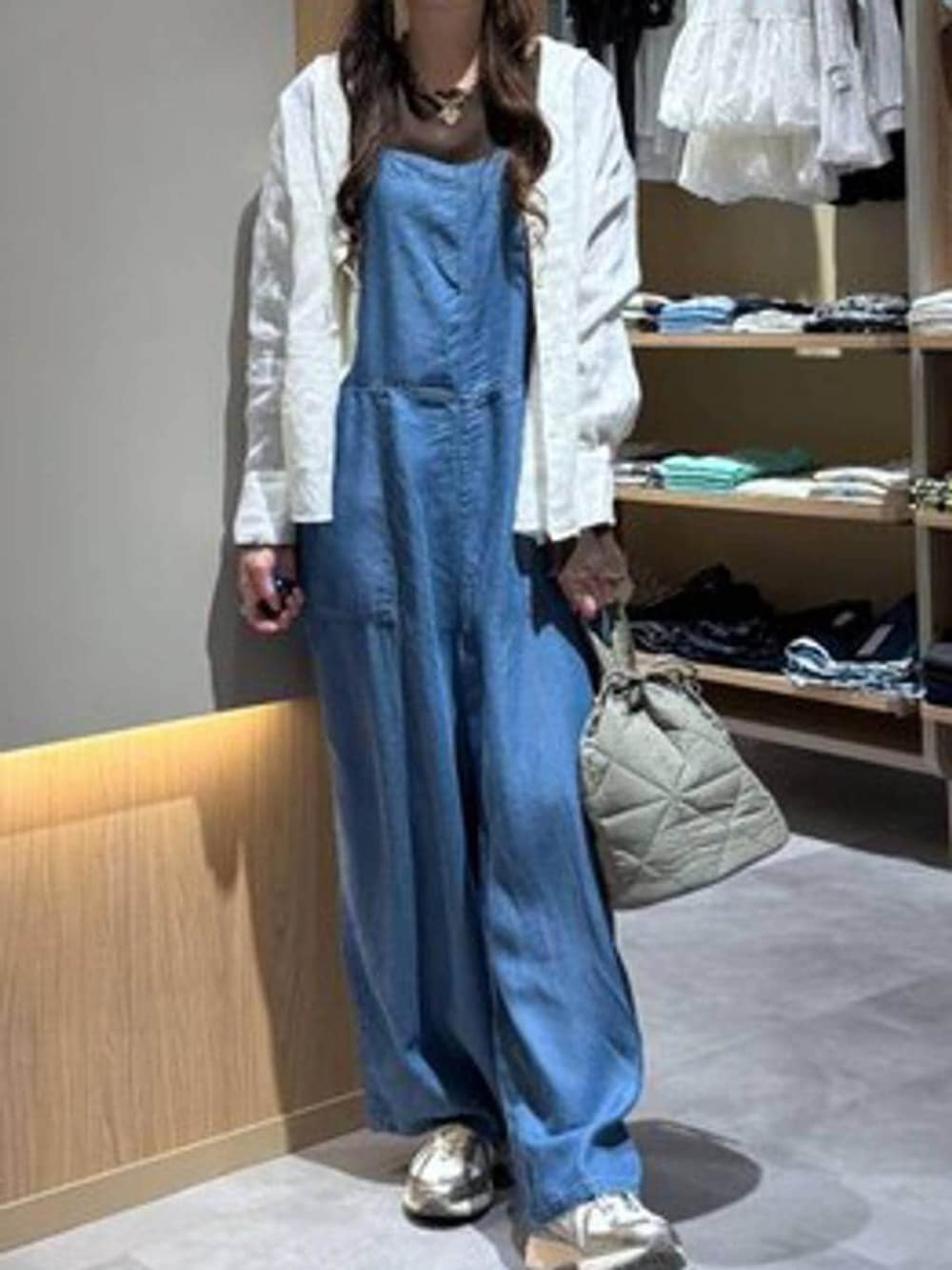 グリーン系のハンドバッグ、ホワイト系のシャツ/ブラウス、ブルー系のサロペット/オーバーオールを着用したレディースの春コーディネートの5枚目の写真