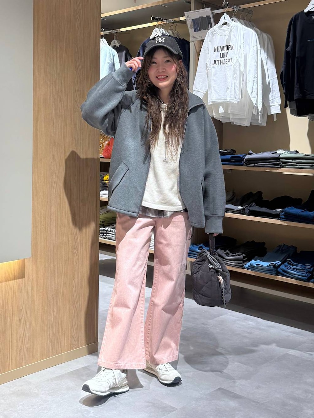 ベージュ系のニット/セーター、グレー系のハンドバッグ、ピンク系のデニムパンツを着用したレディースの春コーディネートの6枚目の写真