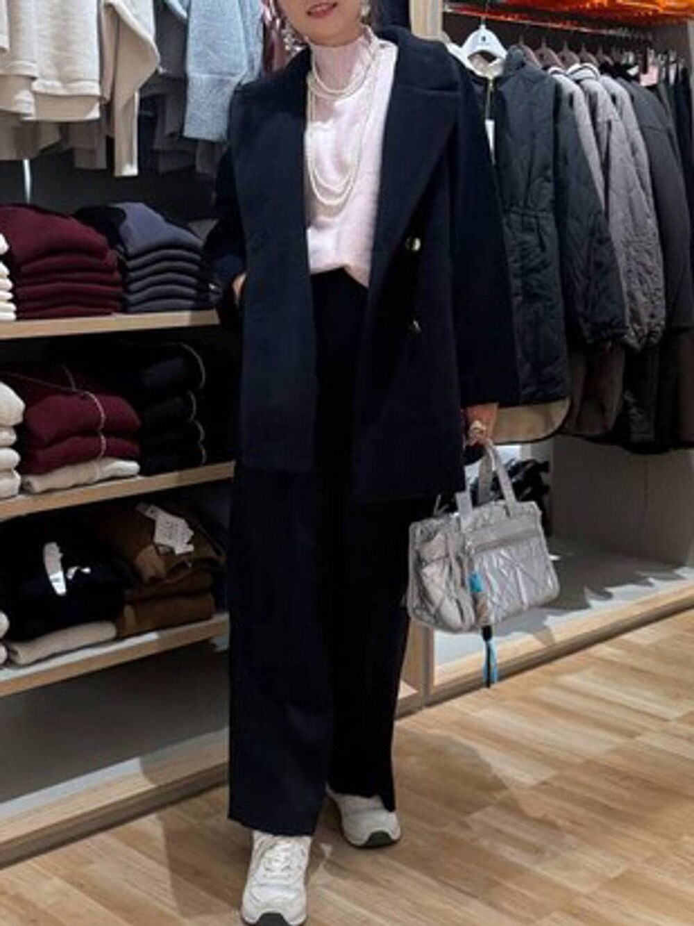 ブルー系のチェスターコート、シルバー系のボストンバッグ、ピンク系のニット/セーターを着用したレディースの冬コーディネートの5枚目の写真