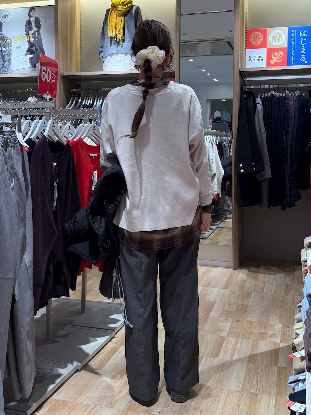 ブラック系のブルゾン、グレー系のハンドバッグ、ホワイト系のニット/セーターを着用したレディースの冬コーディネートの5枚目の写真