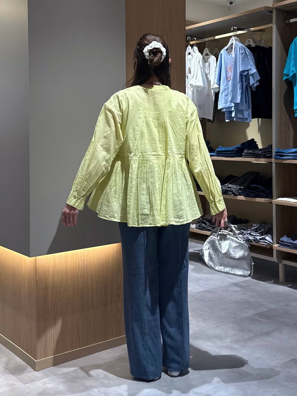 シルバー系のショルダーバッグ、シルバー系のパンプス、ホワイト系のタンクトップを着用したレディースの秋コーディネートの4枚目の写真
