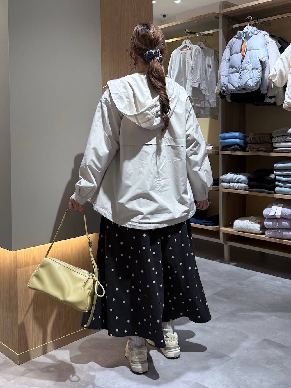 グレー系のニット/セーター、ホワイト系のスウェット、ベージュ系のマウンテンパーカーを着用したレディースの春コーディネートの4枚目の写真