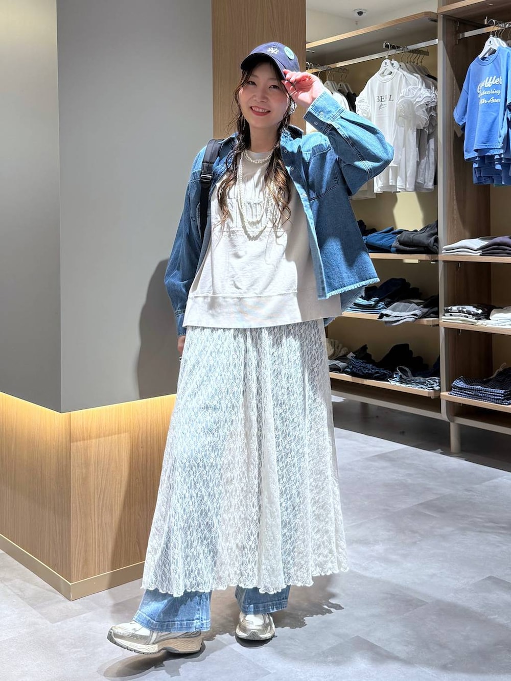 ブルー系のシャツ/ブラウス、ブルー系のデニムパンツ、ベージュ系のTシャツ/カットソーを着用したレディースの夏コーディネートの6枚目の写真
