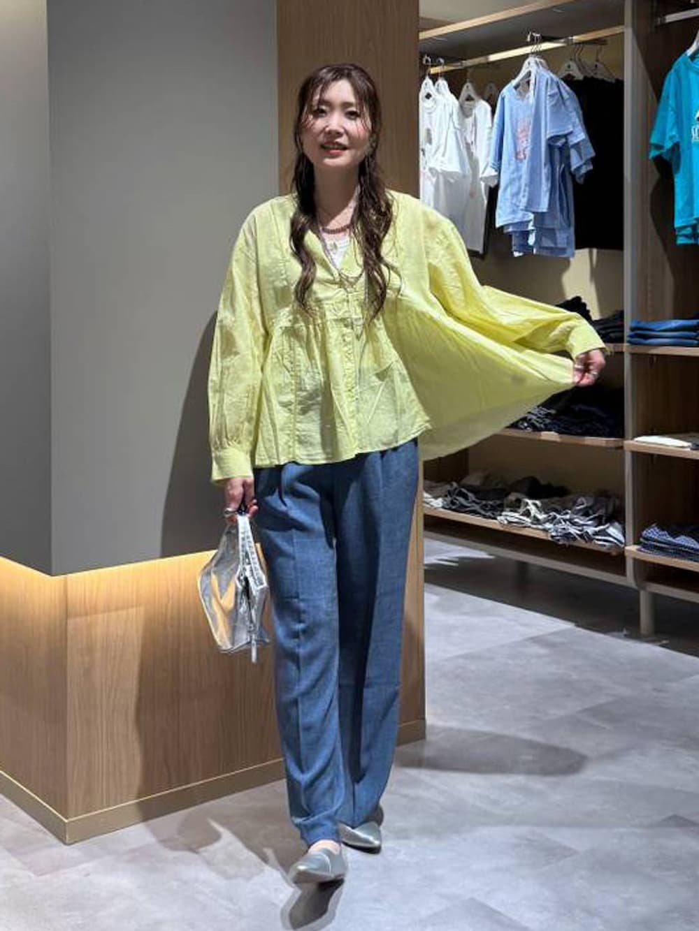 シルバー系のショルダーバッグ、シルバー系のパンプス、ホワイト系のタンクトップを着用したレディースの秋コーディネートの2枚目の写真