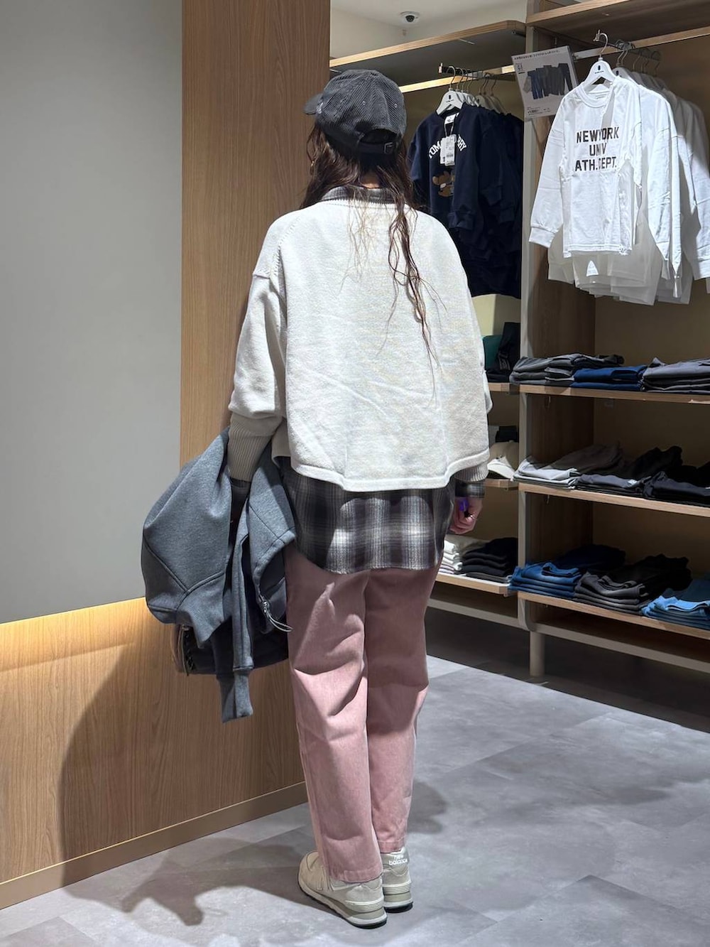 ベージュ系のニット/セーター、グレー系のハンドバッグ、ピンク系のデニムパンツを着用したレディースの春コーディネートの4枚目の写真