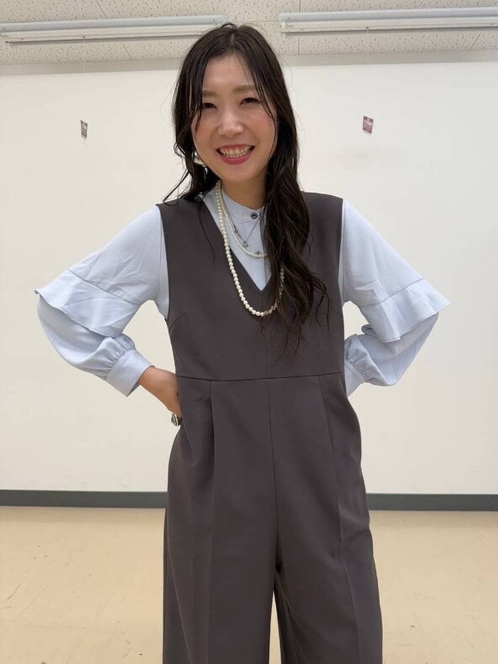 ブラック系のショルダーバッグ、ブラック系のパンプス、グレー系のセットアップを着用したレディースの冬コーディネートの3枚目の写真