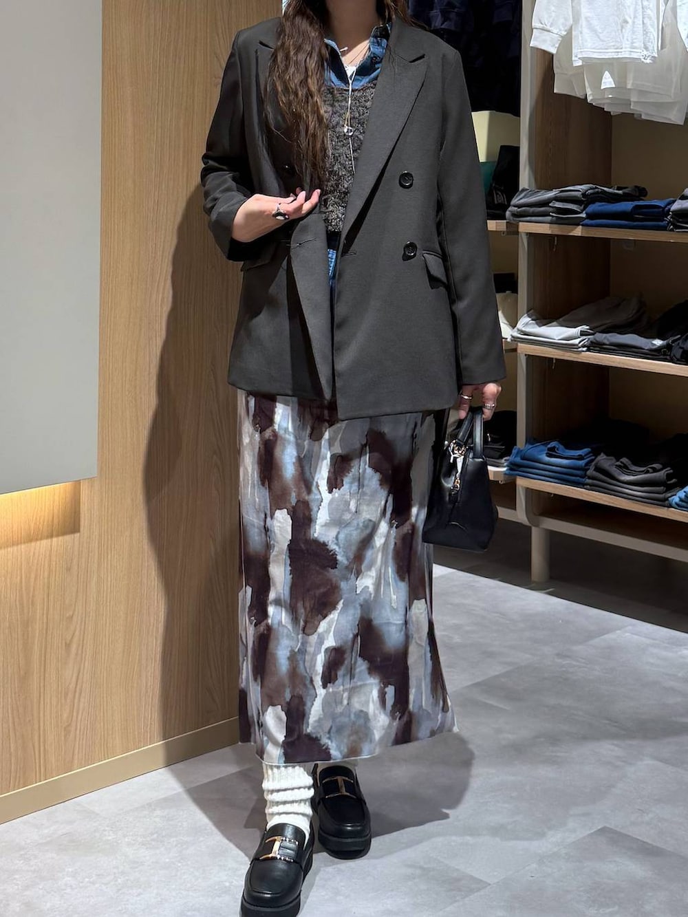 ブラック系のショルダーバッグ、ブラック系のローファー、ブルー系のシャツ/ブラウスを着用したレディースの春コーディネートの5枚目の写真