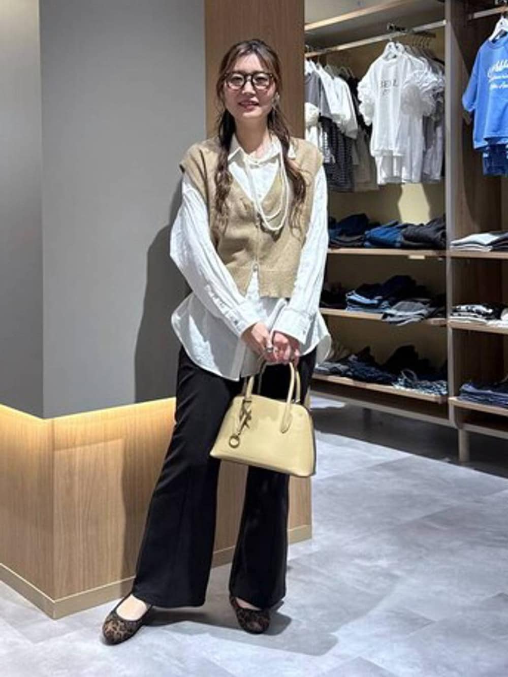 その他のバレエシューズ、イエロー系のショルダーバッグ、ホワイト系のシャツ/ブラウスを着用したレディースの春コーディネートの3枚目の写真